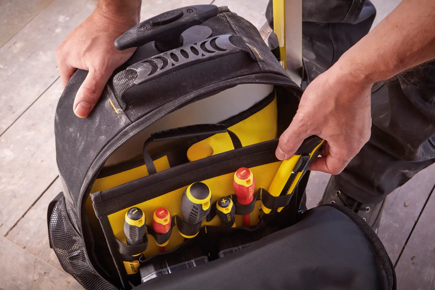 Borsa porta attrezzi STANLEY STST83307-1 con scomparti multipli e utensili manuali, vista dall'alto.