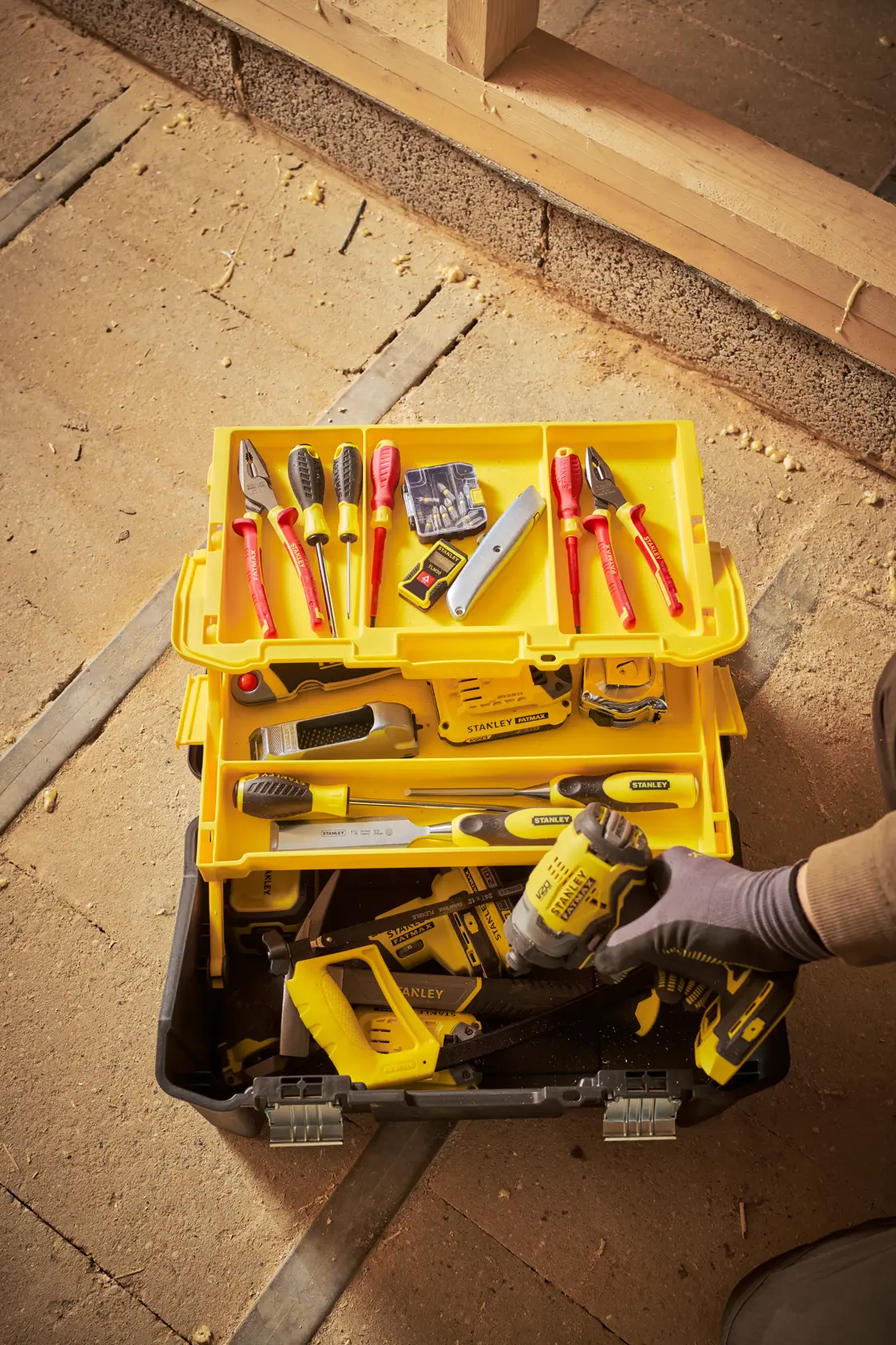 Stanley STST83397-1 cassetta degli attrezzi con utensili manuali assortiti, vassoio giallo e utensile elettrico, vista dall'alto.