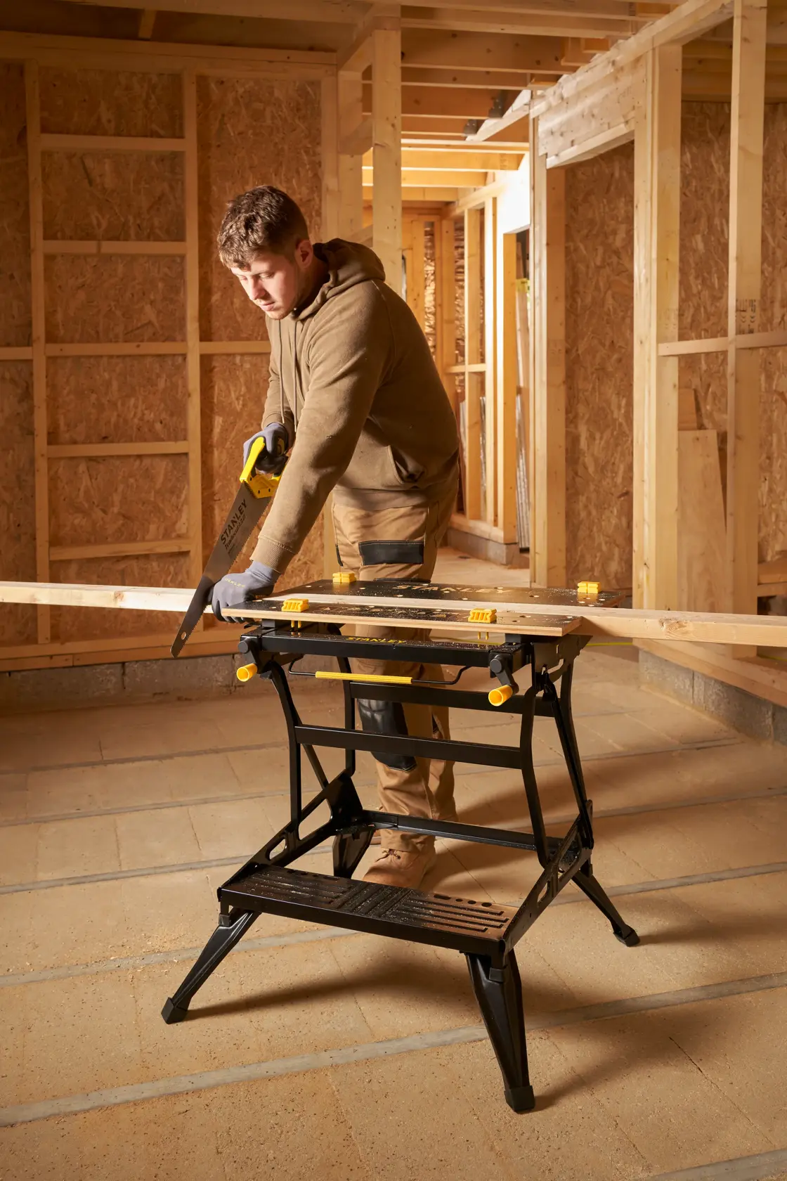 STANLEY STST83800-1 banco da lavoro in uso su cantiere, sostiene asse di legno, categoria fotografia.